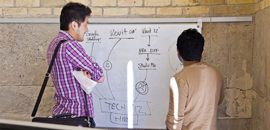 two graduate students in front of a white board