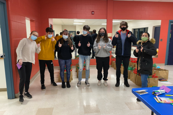 Seven students give the thumbs up while wearing medical face masks