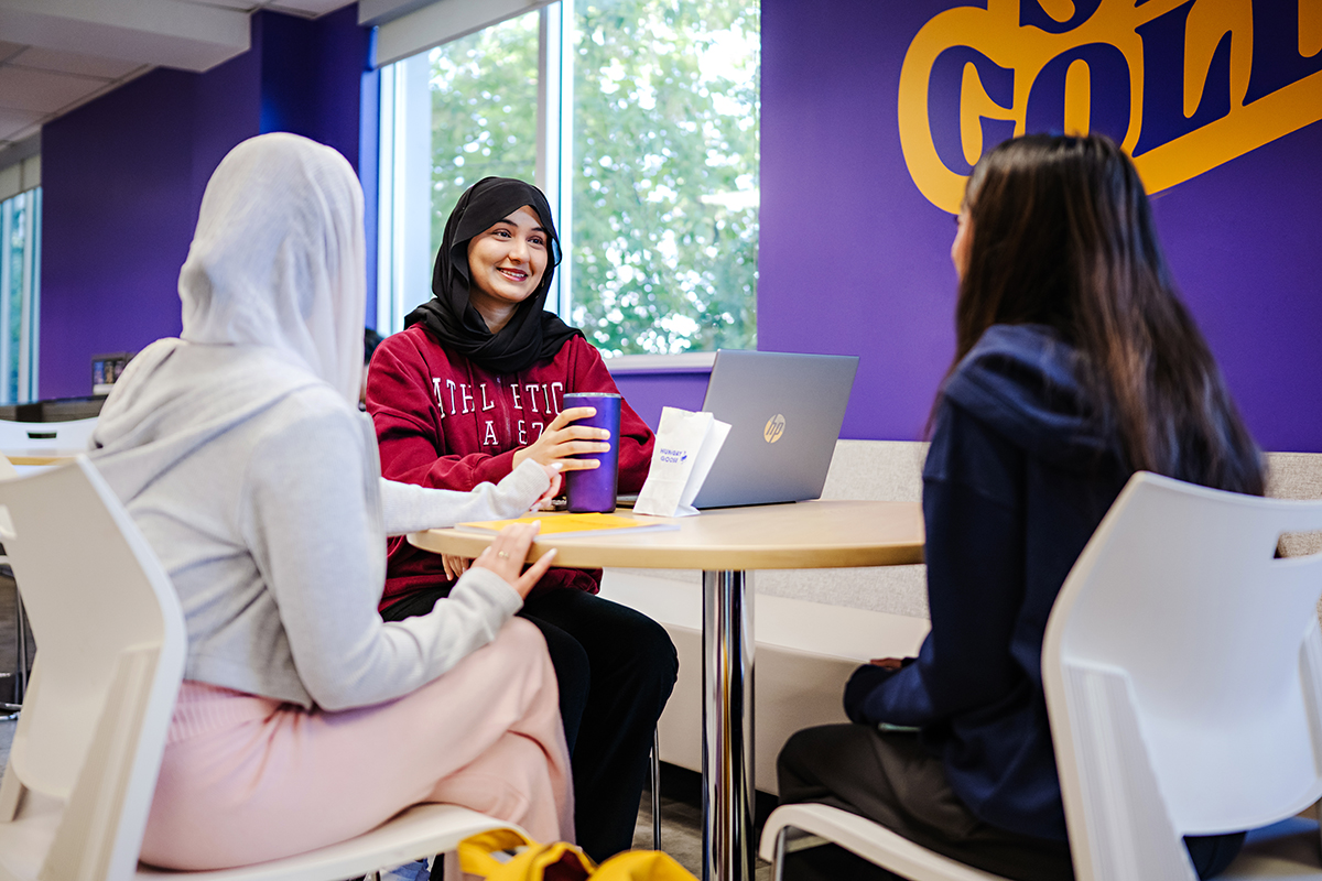 Three students sitting at table